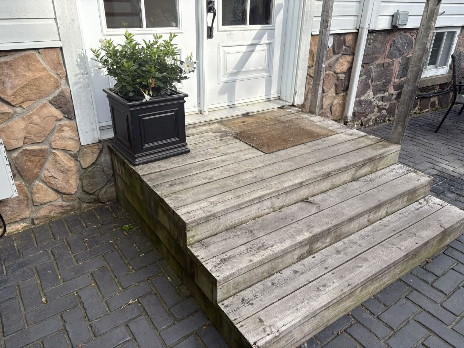 Front porch and wooden steps before — weathered, gray, moss-stained boards