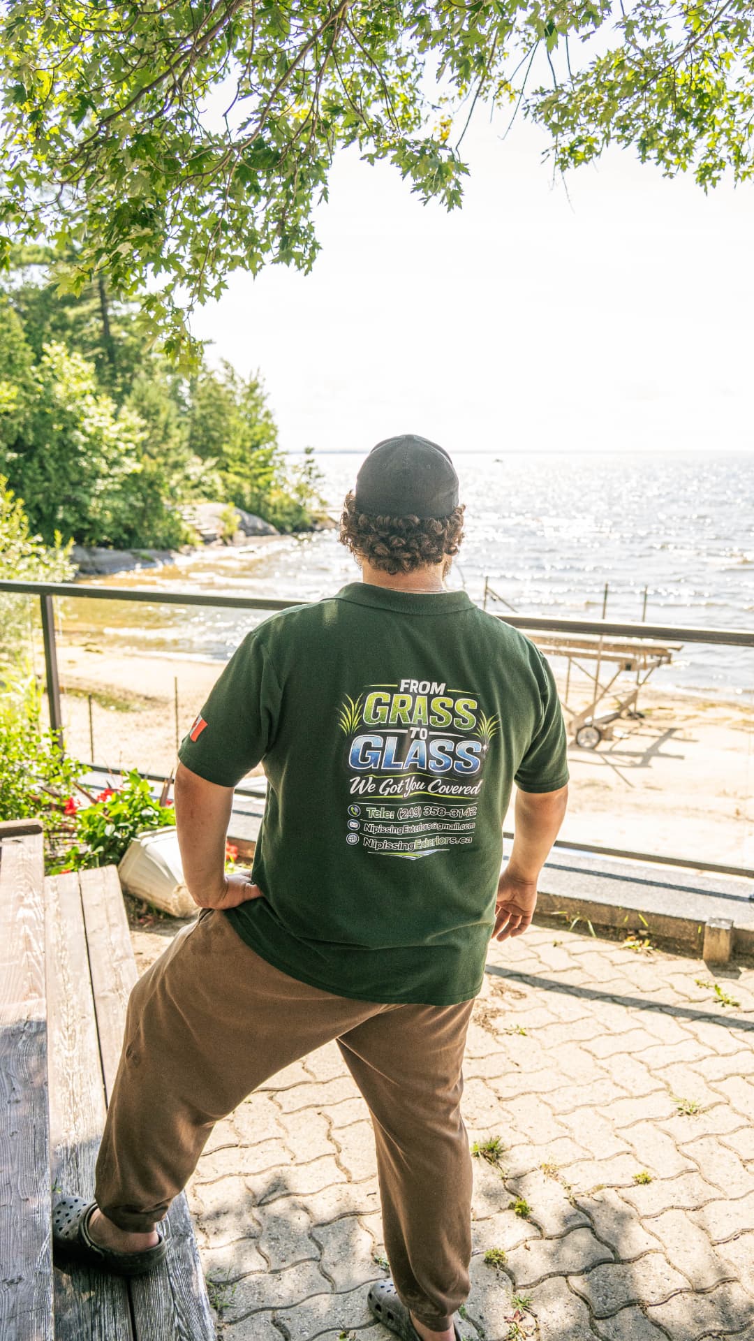 Nipissing Exteriors technician overlooking a North Bay lake in branded company gear